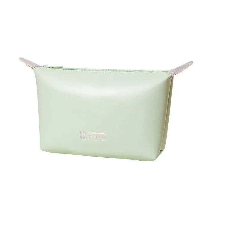 Astuccio cosmetico verde menta in pelle sintetica, design minimalista, chiusura a zip, ideale per trucchi e accessori da viaggio.