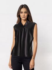 Donna con top nero senza maniche, elegante e moderno, su sfondo bianco. Moda femminile, abbigliamento casual chic, stile minimalista.
