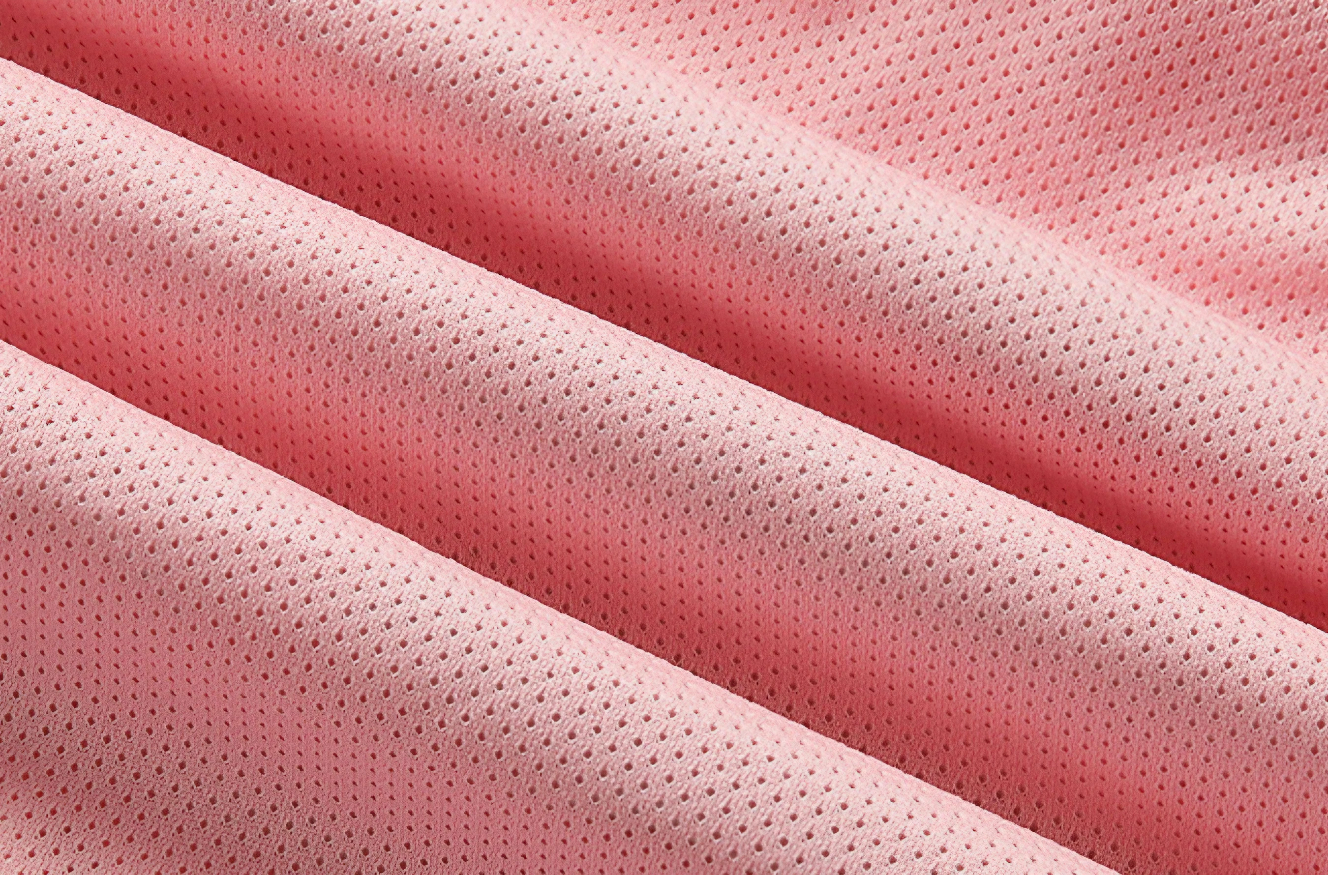Tessuto a rete rosa, traspirante e leggero, ideale per abbigliamento sportivo e accessori moda. Materiale resistente e di alta qualità.