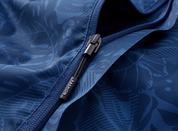 Giacca blu con cerniera, motivo floreale, tessuto impermeabile. Design elegante, ideale per moda outdoor. Accessorio con etichetta "Fashion".