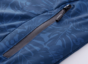 Giacca sportiva blu con motivo foglie tropicali, cerniera nera resistente, tessuto impermeabile. Ideale per attività outdoor e tempo libero.