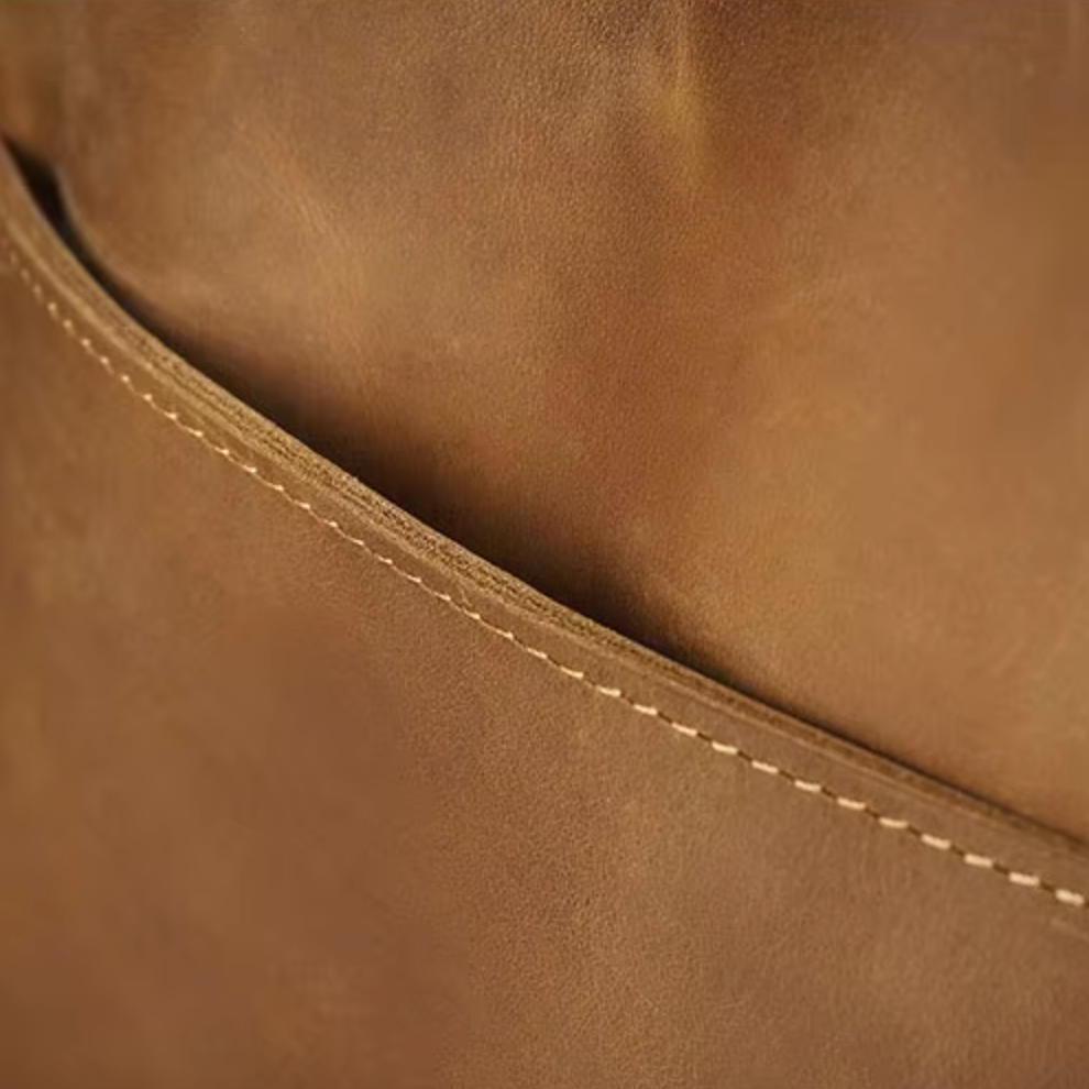 Cuoio marrone con cuciture a vista, texture liscia e dettagli artigianali. Materiale di alta qualità per borse o accessori moda eleganti.