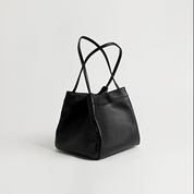 Borsa a mano in pelle nera elegante con doppio manico, design minimalista, perfetta per moda donna, accessorio di lusso, stile contemporaneo.