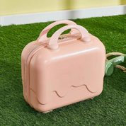 Valigia rosa a forma di gelato su prato verde, design moderno e compatto, ideale per viaggi brevi. Accessorio da viaggio elegante e funzionale.