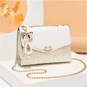 Borsa a tracolla elegante bianca con dettagli dorati e decorazione di perle, perfetta per eventi formali. Accessorio moda donna chic.