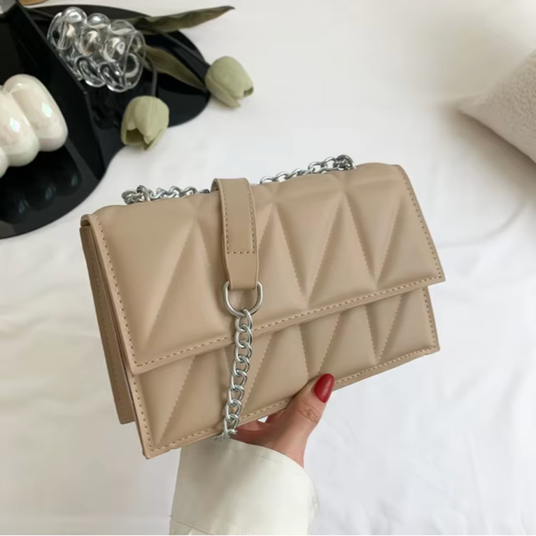 Borsa a tracolla beige trapuntata con catena argentata, design elegante e moderno, perfetta per moda donna, accessorio chic e versatile.