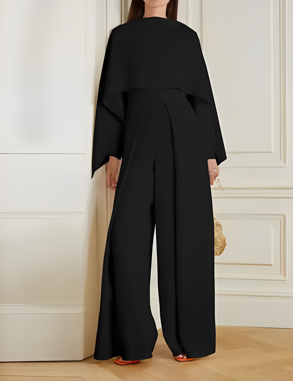 Tuta elegante nera da donna, design moderno con maniche ampie, perfetta per eventi formali. Accessorio borsa dorata. Moda femminile di lusso.