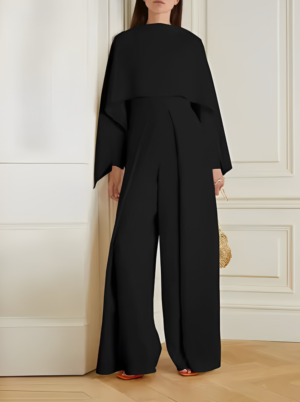 Tuta elegante nera da donna, design moderno con maniche ampie, perfetta per eventi formali. Accessorio borsa dorata. Moda femminile di lusso.