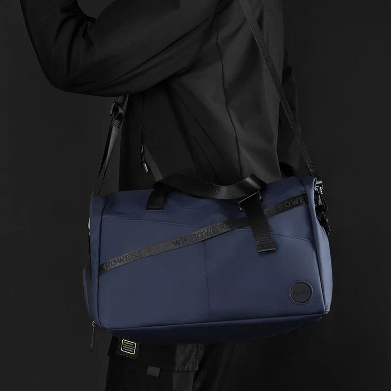 Borsa a tracolla blu scuro, design moderno, tessuto resistente, ideale per viaggi e sport. Uomo in abbigliamento nero. Accessorio versatile ed elegante.