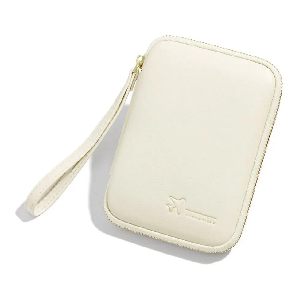 Custodia portadocumenti da viaggio in pelle beige con cerniera e cinturino, design elegante e compatto, ideale per passaporti e carte di credito.