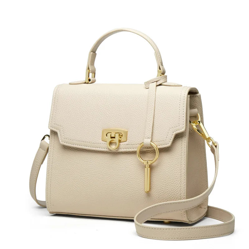 Borsa a tracolla in pelle beige con chiusura dorata, manico superiore e tracolla regolabile. Elegante accessorio moda donna.
