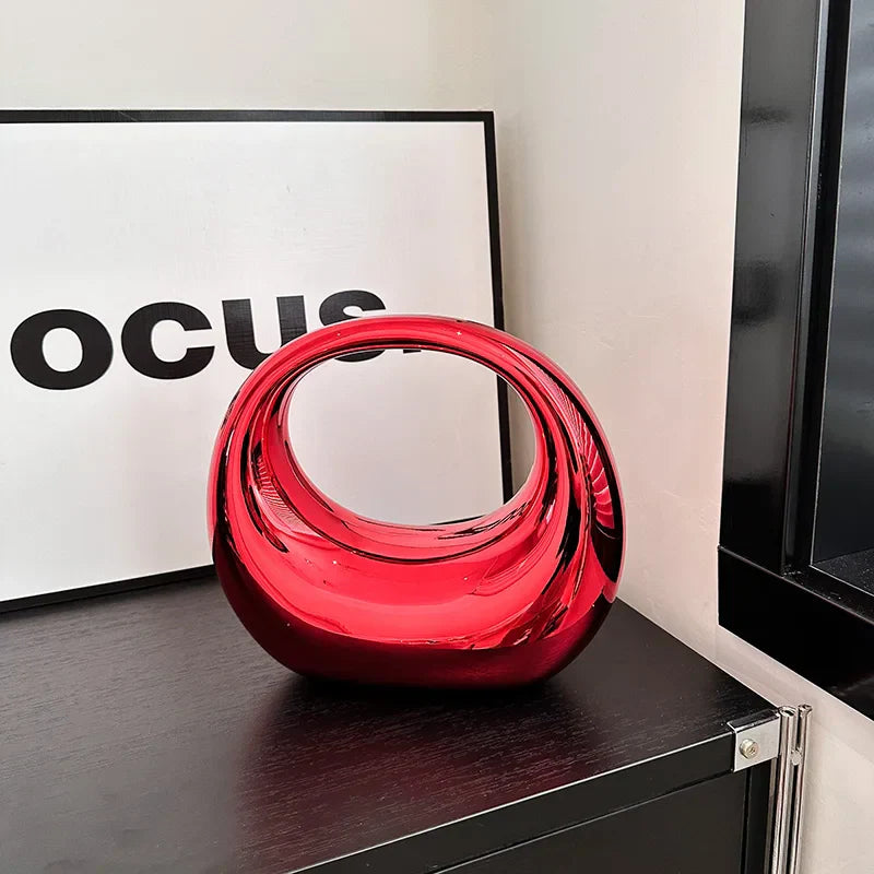 Vaso decorativo moderno in vetro rosso lucido su mobile nero, design contemporaneo, ideale per arredamento casa, soggiorno o ufficio.