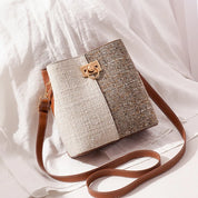 Borsa a tracolla in tessuto tweed beige e marrone, con chiusura dorata e cinturino in pelle regolabile. Elegante accessorio moda donna.