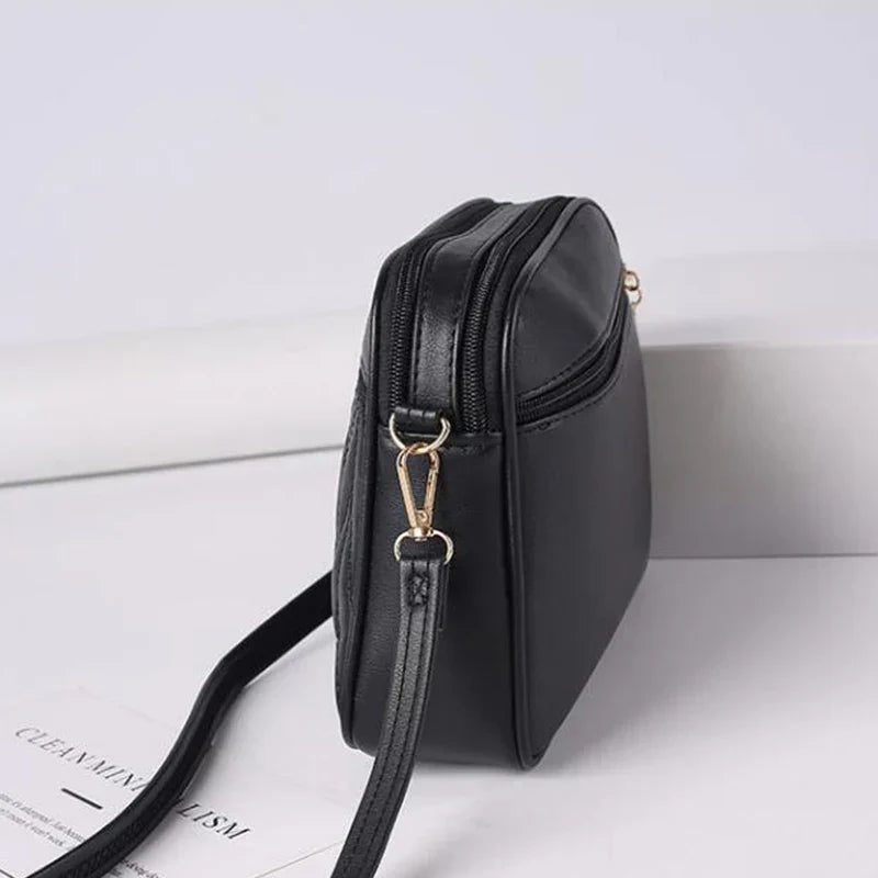 Borsa a tracolla in pelle nera, design minimalista, chiusura con zip, ideale per moda donna, accessorio elegante e versatile.