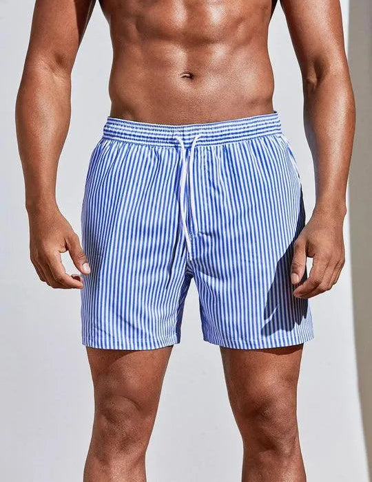 Costume da bagno uomo a righe blu e bianche, elastico in vita, lunghezza media. Ideale per nuoto e spiaggia. Tessuto leggero e traspirante.