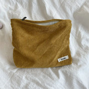 Borsa a tracolla in velluto a coste marrone su letto bianco, con etichetta "Sazak", ideale per moda autunnale e accessori casual.