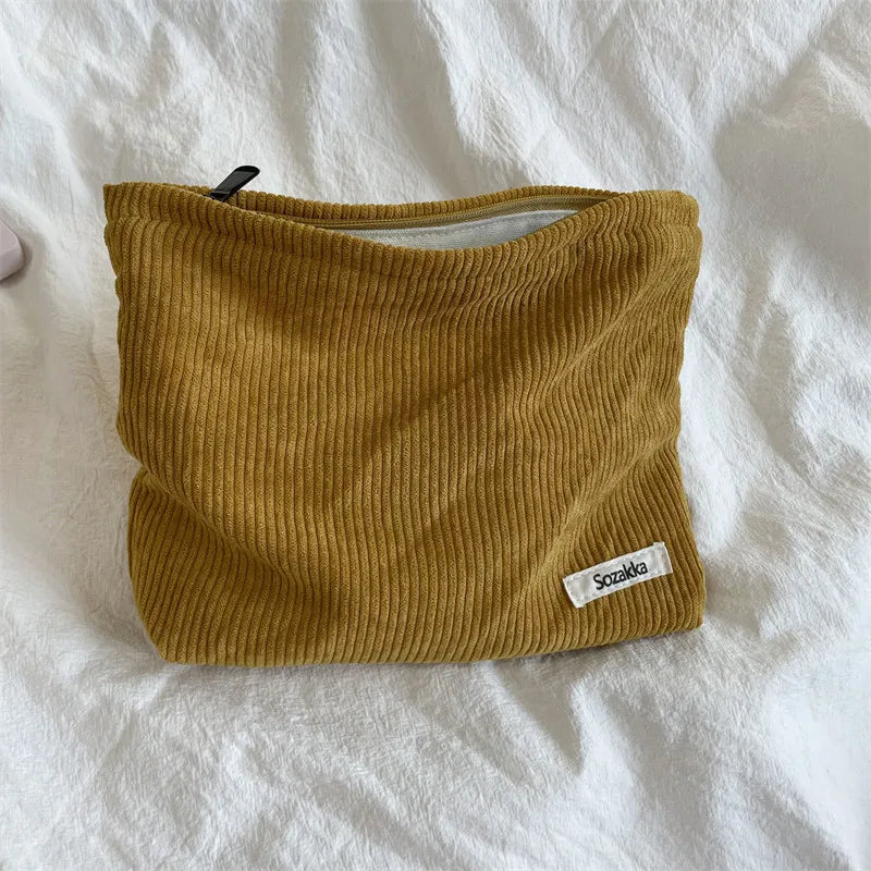 Borsa a tracolla in velluto a coste marrone su letto bianco, con etichetta "Sazak", ideale per moda autunnale e accessori casual.