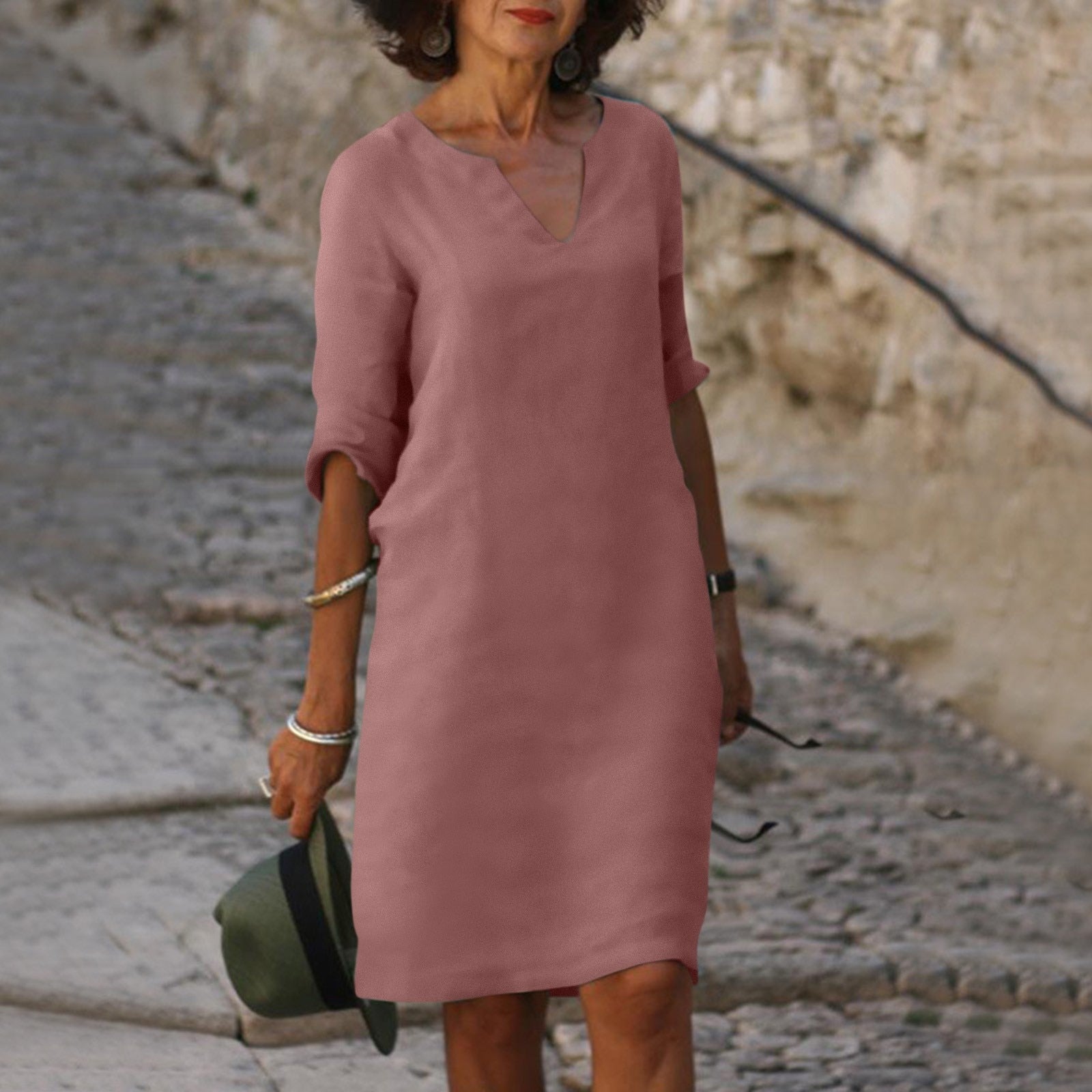Abito estivo rosa donna, maniche a tre quarti, scollo a V, stile casual elegante, perfetto per passeggiate estive. Accessori: cappello e bracciali.