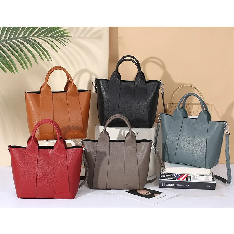 Cinque borse a mano in pelle PU in vari colori (rosso, marrone, nero, grigio, blu) su sfondo neutro, eleganti e moderne, perfette per ogni occasione.