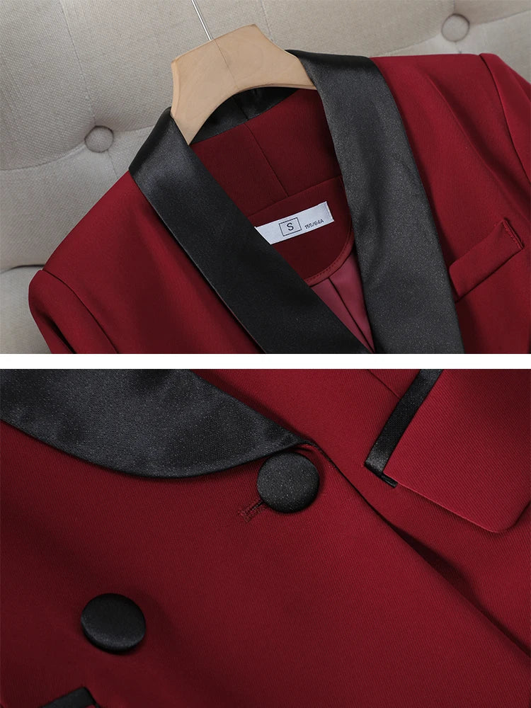 Giacca elegante da donna in tessuto rosso con colletto e bottoni neri in raso, appesa su gruccia di legno. Design moderno e sofisticato.