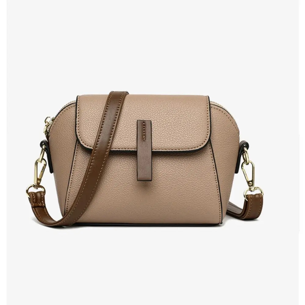 Borsa a tracolla in pelle beige con chiusura a patta, dettagli dorati e tracolla regolabile marrone. Elegante accessorio moda donna.