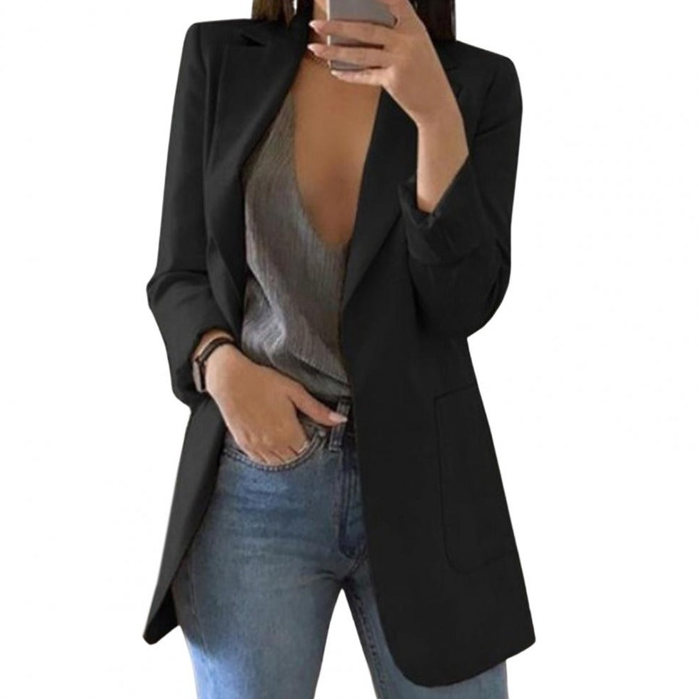 Giacca blazer donna nera elegante, abbinata a top grigio scollato e jeans casual. Moda femminile, abbigliamento versatile per ufficio e tempo libero.