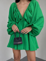 Donna con abito verde scollato e borsa nera Jacquemus. Moda elegante, abbigliamento femminile, tendenze 2023, stile contemporaneo.