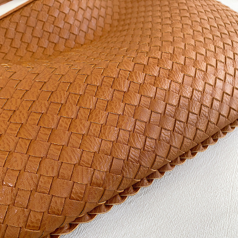 Borsa intrecciata in pelle marrone, design elegante e artigianale, accessorio moda di lusso, texture dettagliata, stile sofisticato.