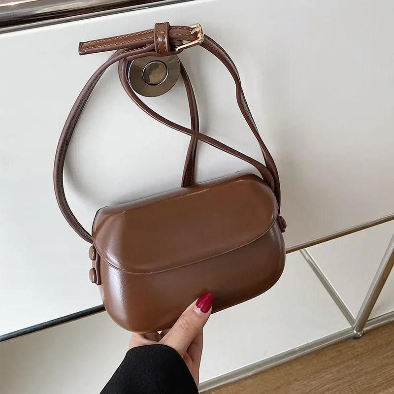 Borsa a tracolla in pelle marrone, design elegante e compatto, chiusura con patta, ideale per moda donna. Accessorio versatile e di tendenza.