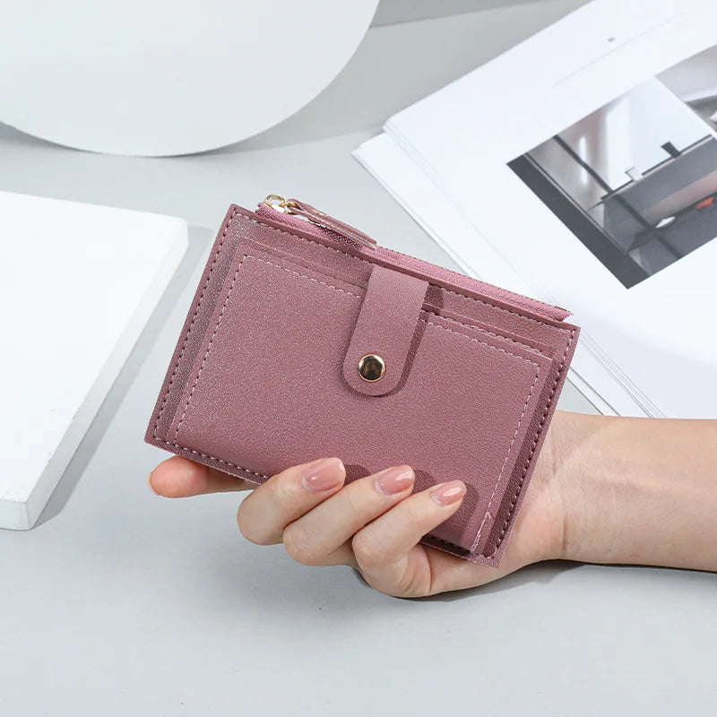 Portafoglio donna rosa in pelle sintetica, compatto e elegante, con chiusura a bottone. Ideale per carte e contanti. Accessorio moda femminile.