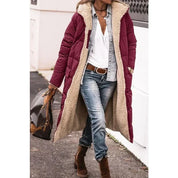 Donna con cappotto lungo imbottito bordeaux, camicia bianca, jeans e stivali marroni. Moda invernale casual, look urbano elegante.