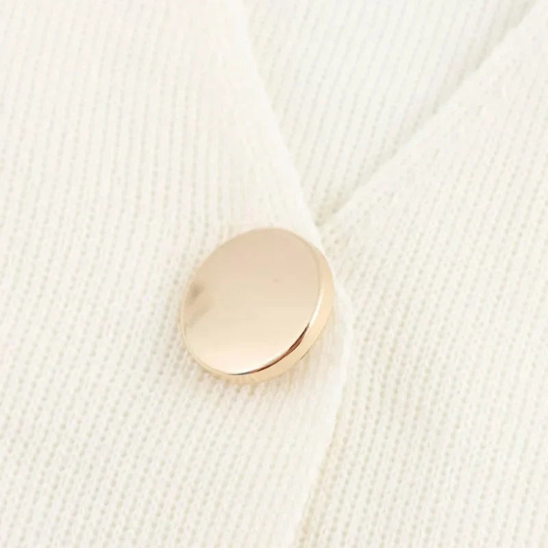 Cardigan bianco in lana con bottone dorato, dettaglio elegante e minimalista. Maglione donna, moda autunno inverno, abbigliamento casual chic.
