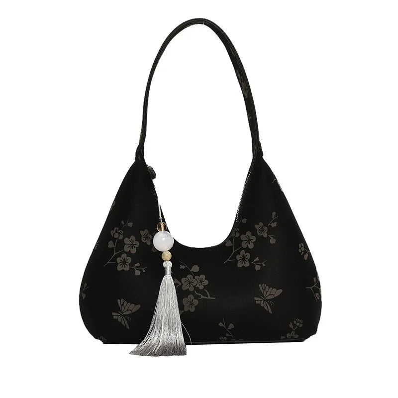 Borsa a spalla nera con motivo floreale, decorazione con nappina e perla. Elegante accessorio moda donna, perfetto per eventi serali.