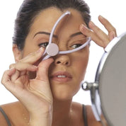 Donna utilizza strumento per misurare sopracciglia davanti a specchio. Accessorio per trucco, modellazione sopracciglia, bellezza femminile.