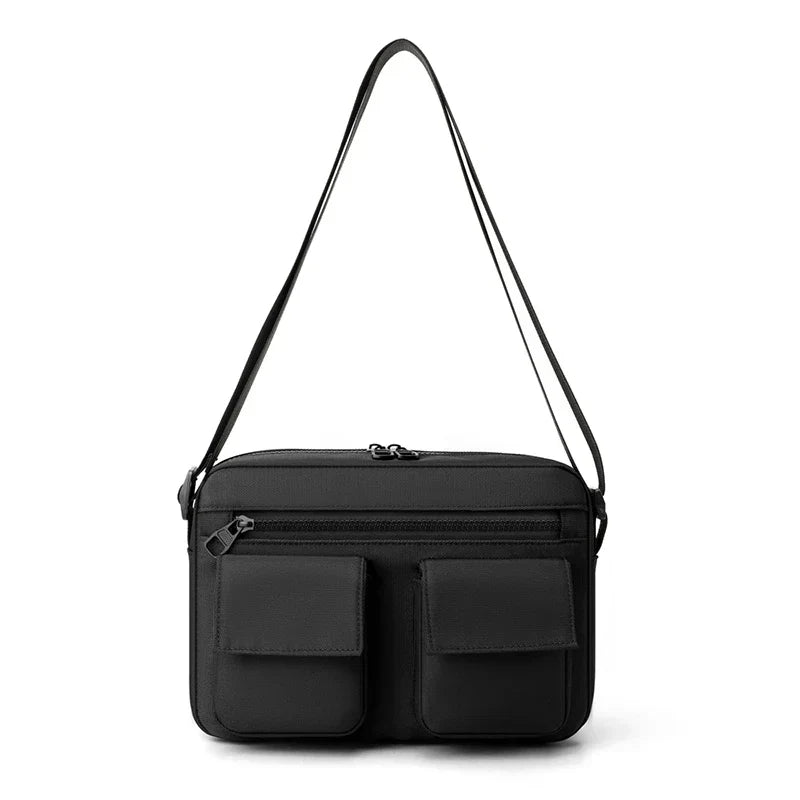 Borsa a tracolla nera in pelle con doppie tasche frontali, chiusura a zip, design elegante e moderno. Accessorio moda uomo e donna.