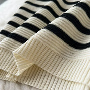 Maglione a righe bianche e nere in lana, tessuto a coste, dettaglio del bordo. Moda invernale, abbigliamento caldo, stile casual elegante.