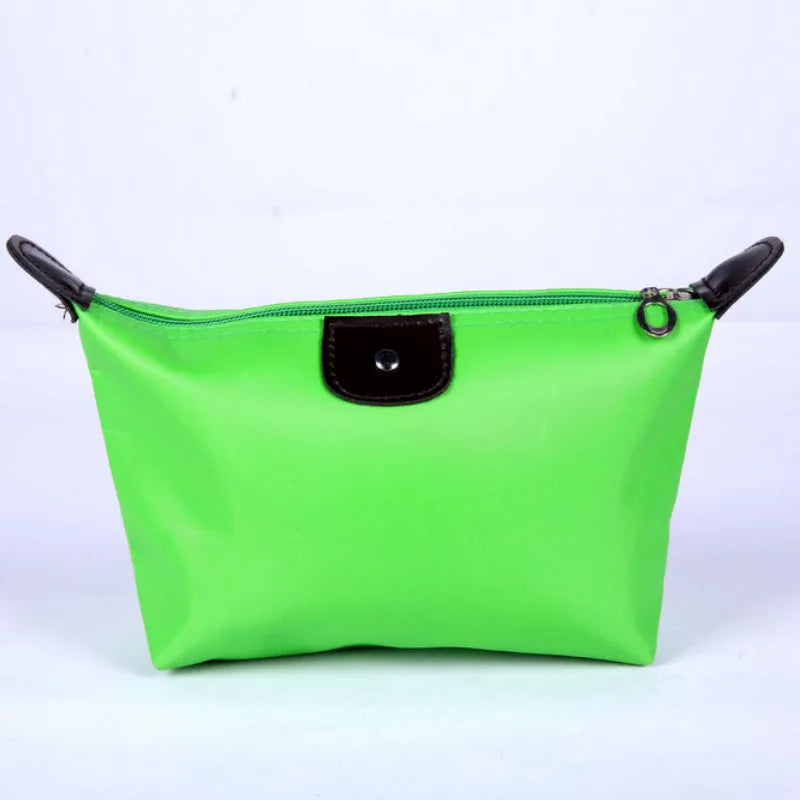 Borsa cosmetica verde brillante con cerniera e dettagli in pelle nera, ideale per trucco e accessori da viaggio. Design elegante e funzionale.