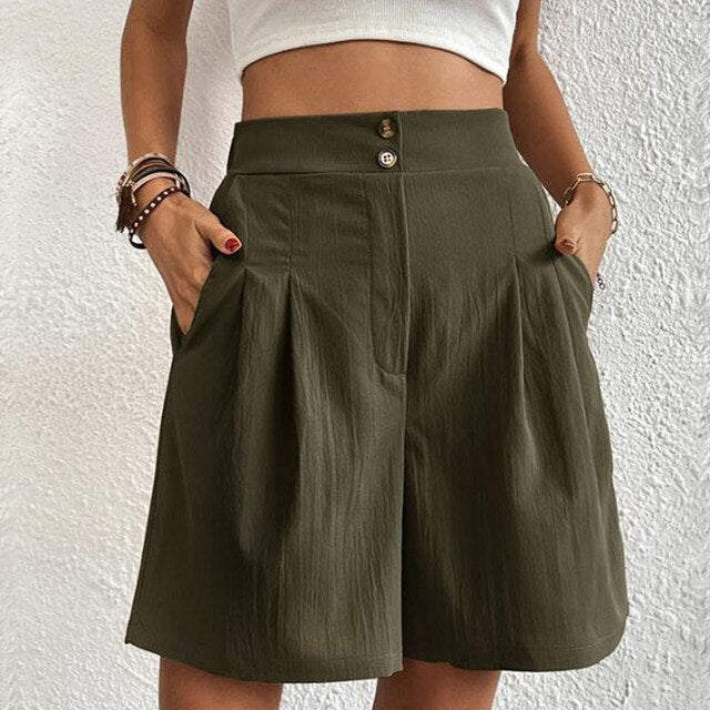 Shorts a vita alta verde oliva da donna, con tasche laterali e bottoni, indossati con top bianco. Stile casual estivo, moda femminile.