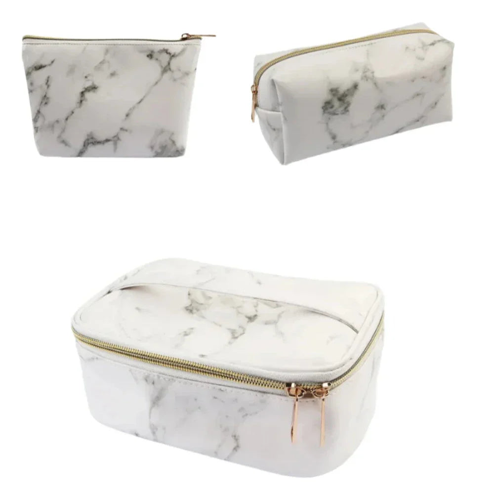 Set di tre beauty case in similpelle effetto marmo bianco con cerniera dorata, ideali per cosmetici e accessori da viaggio.