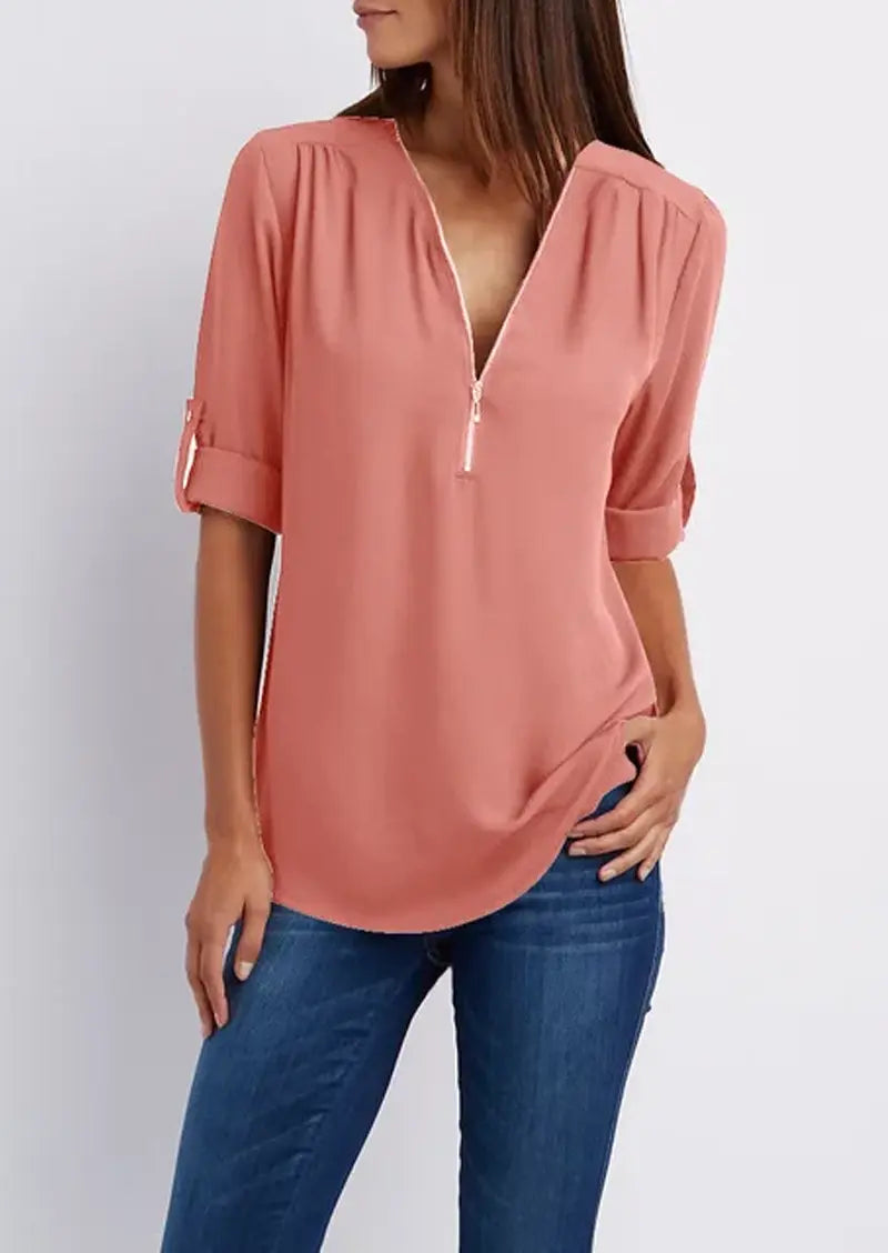 Blusa donna rosa con zip, maniche a 3/4 arrotolate, scollo a V, abbinata a jeans. Elegante e casual, perfetta per moda femminile quotidiana.