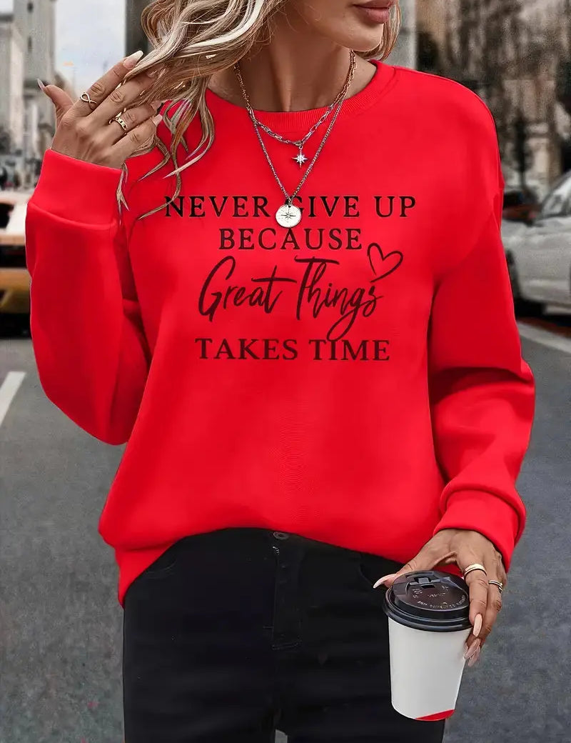 Donna con felpa rossa con scritta motivazionale, collane a strati, anelli, e caffè da asporto. Moda casual, abbigliamento autunnale, street style.