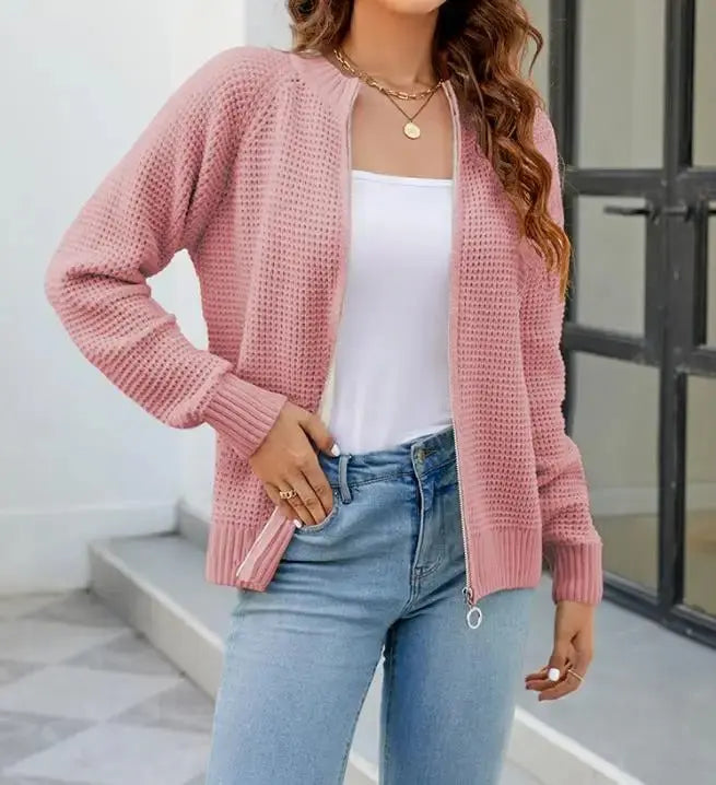 Donna con cardigan rosa lavorato a maglia, top bianco e jeans chiari. Moda casual femminile, abbigliamento autunnale, stile confortevole.