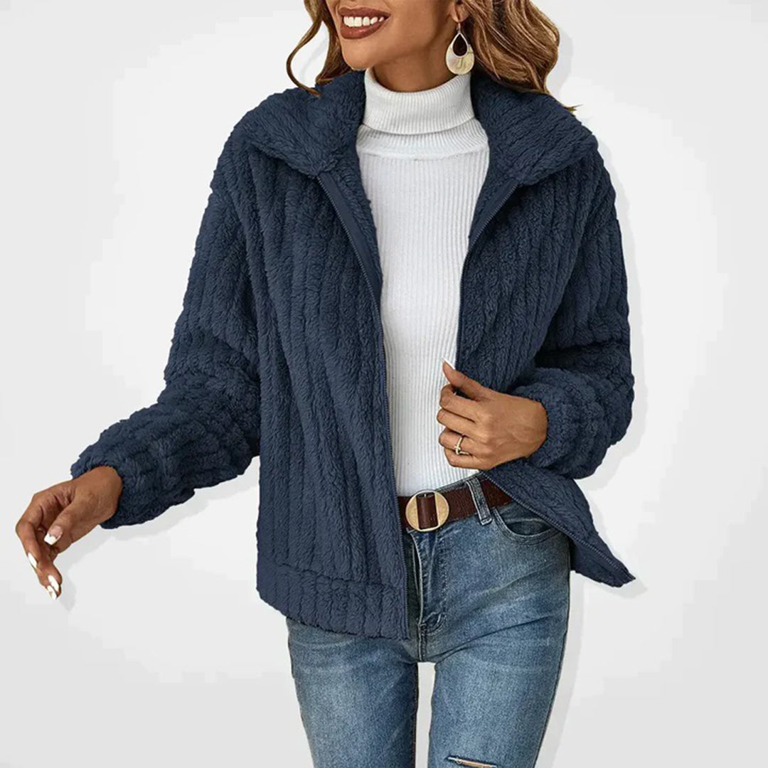 Giacca in pile blu scuro da donna, design casual, abbinata a dolcevita bianco e jeans. Moda autunnale, stile elegante e confortevole.