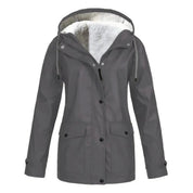 Giacca impermeabile grigia da donna con cappuccio, fodera in pelliccia sintetica, tasche frontali e chiusura a bottoni. Ideale per l'inverno.