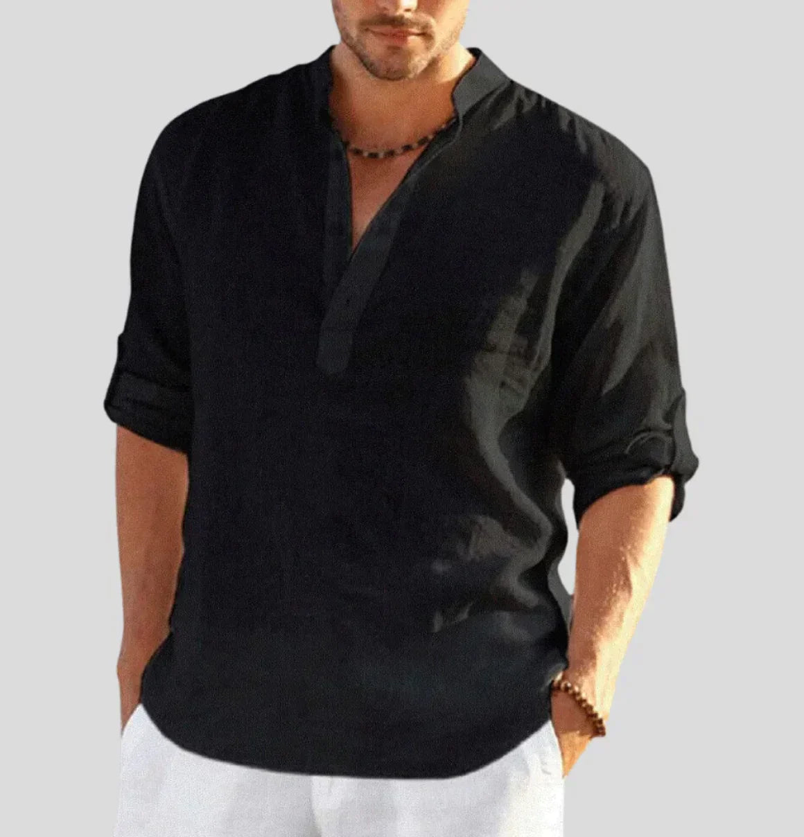 Camicia uomo nera casual in lino, maniche lunghe, colletto alla coreana, abbinata a pantaloni bianchi. Stile estivo elegante e rilassato.
