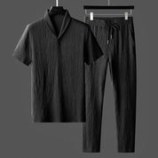Completo uomo nero in tessuto strutturato, camicia a maniche corte e pantaloni con coulisse. Elegante abbigliamento estivo casual.