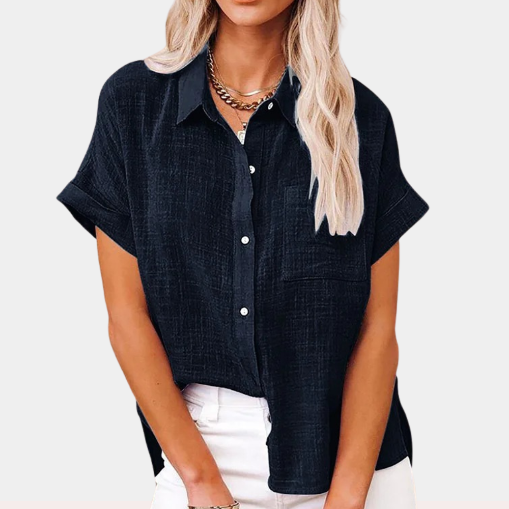 Blusa nera da donna con maniche corte, colletto classico e bottoni, abbinata a pantaloni bianchi. Stile casual elegante, moda femminile.