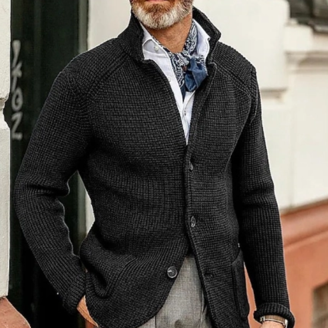 Uomo con cardigan nero a maglia, camicia bianca e cravatta blu. Moda maschile elegante, abbigliamento autunnale, stile casual chic.