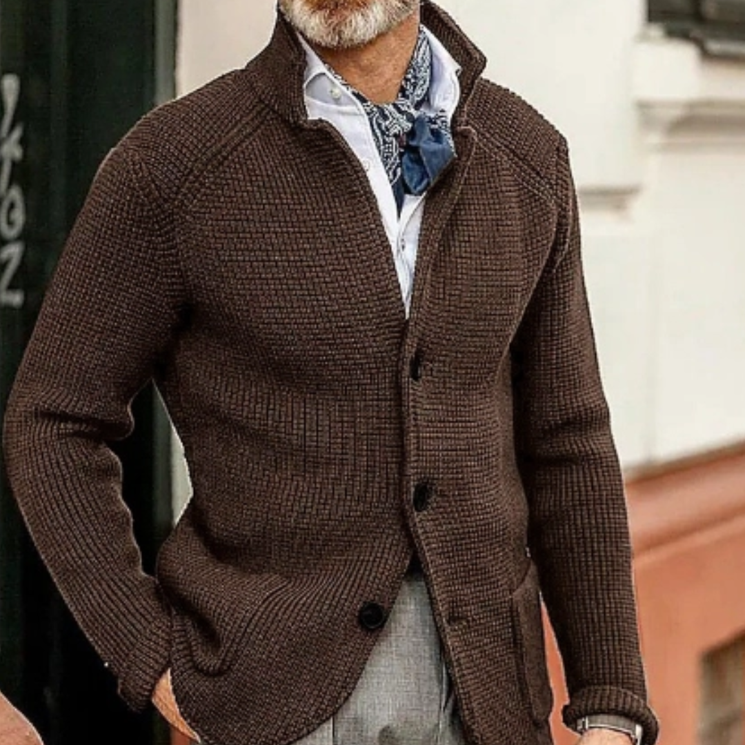 Giacca cardigan marrone uomo, tessuto a maglia, abbinata a camicia bianca e foulard blu. Moda autunnale elegante, stile casual chic.