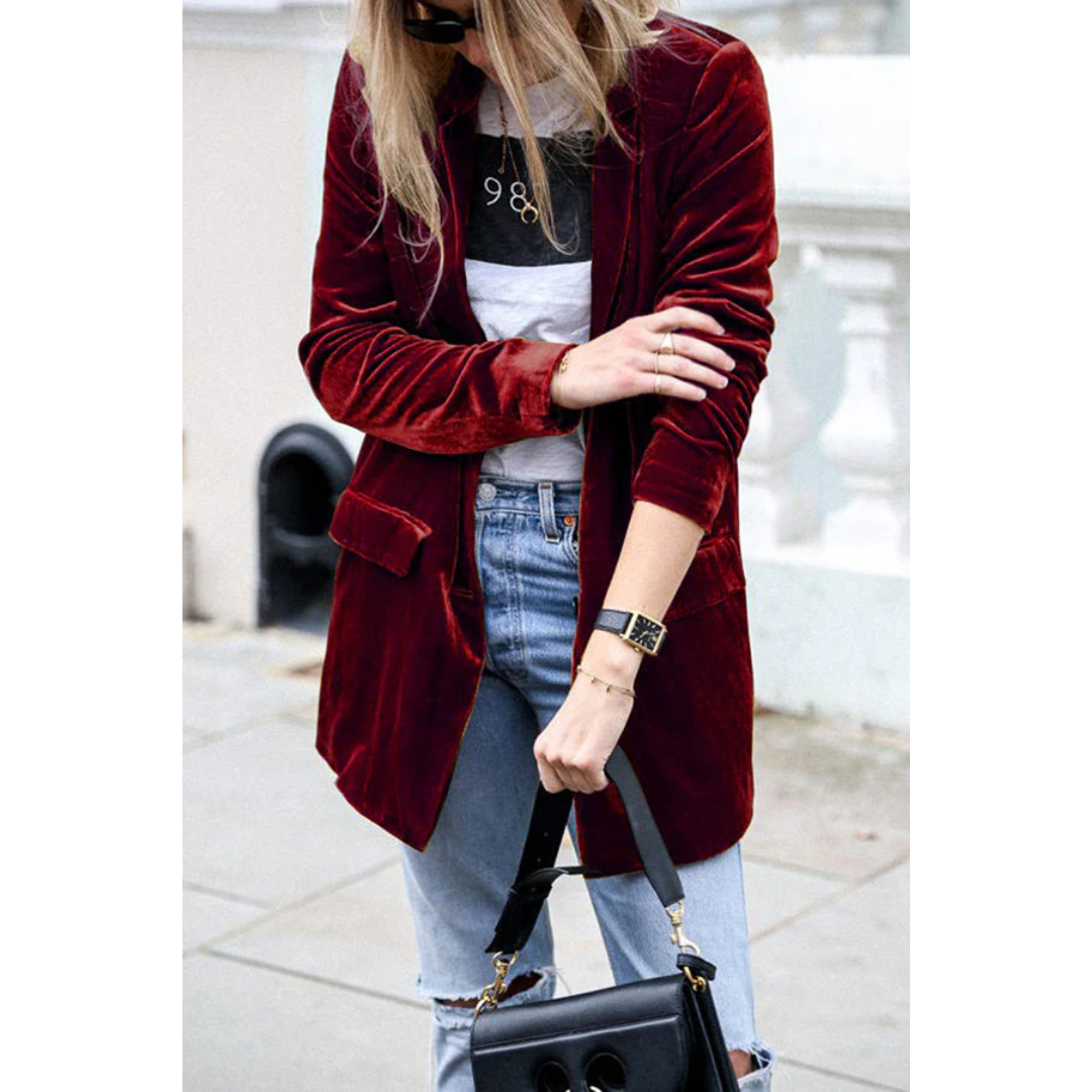 Giacca di velluto rosso donna, abbinata a jeans strappati e borsa nera. Moda autunnale casual chic, stile urbano elegante.